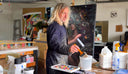 Krovblit applying a resin top coat to an original mixed media collage artwork, adding a high-gloss finish to layered materials.